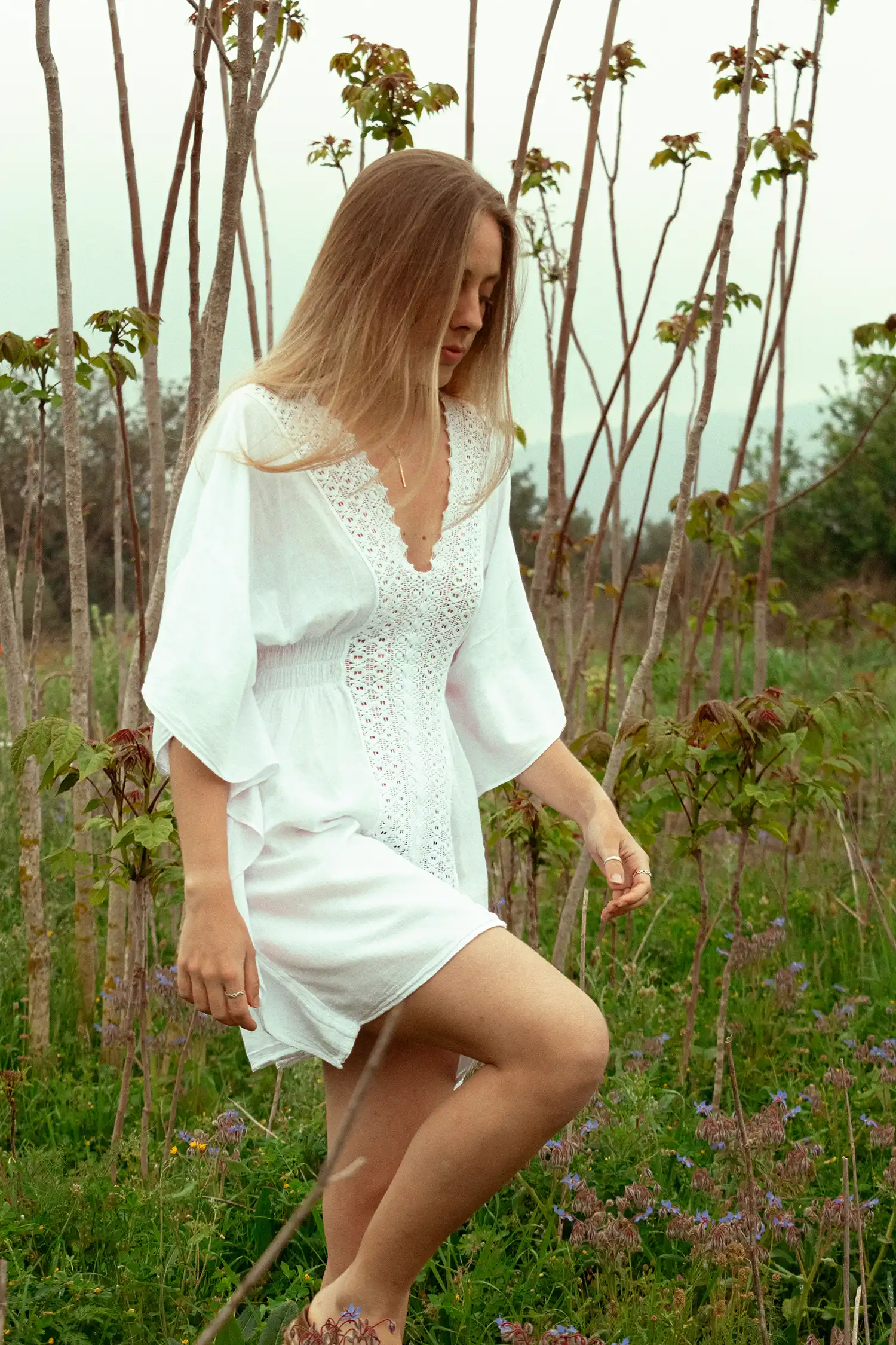 Modelo femenina con caftán ibicenco blanco en el campo