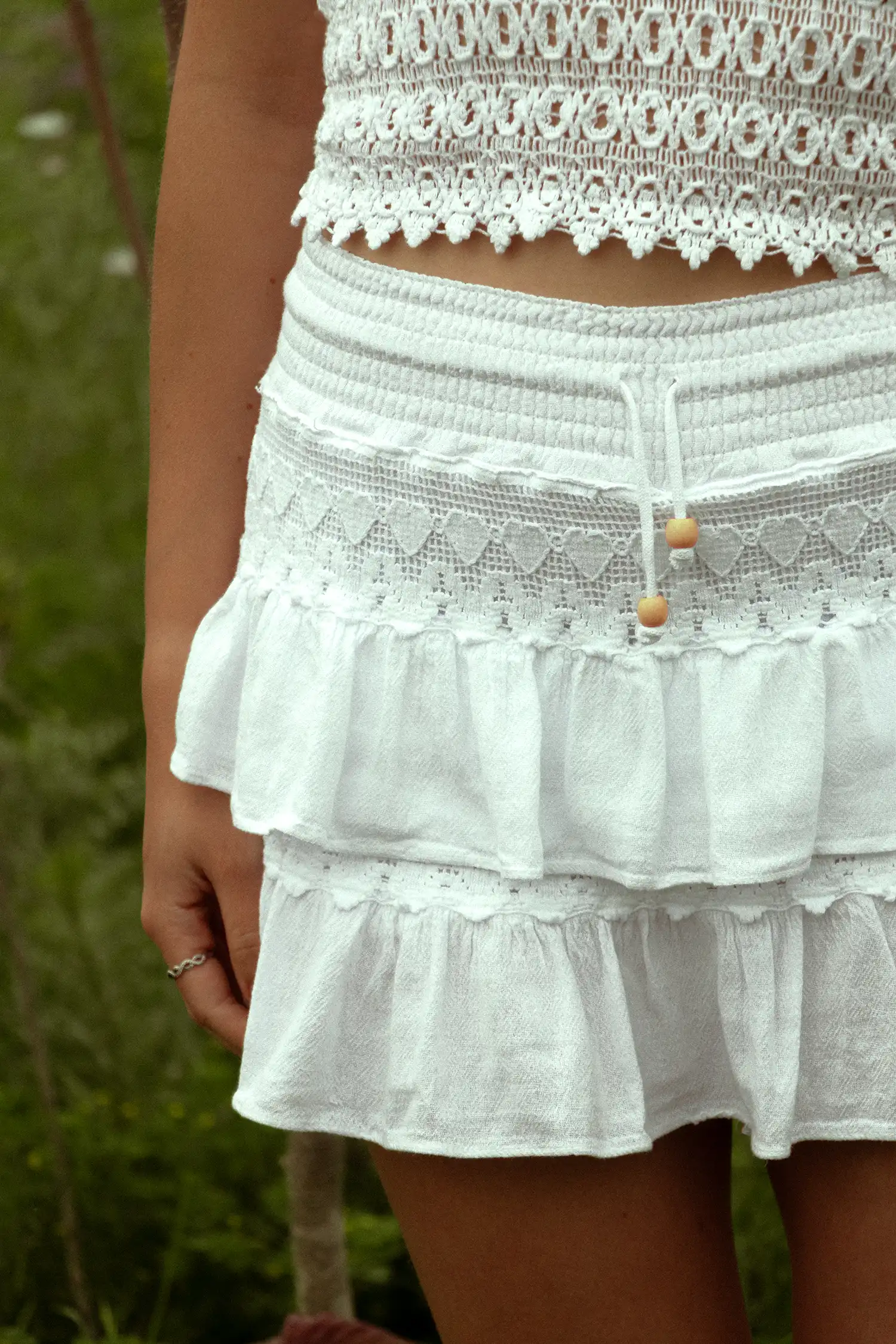 Modelo femenina con una falda ibicenca blanca en el campo vista detalle