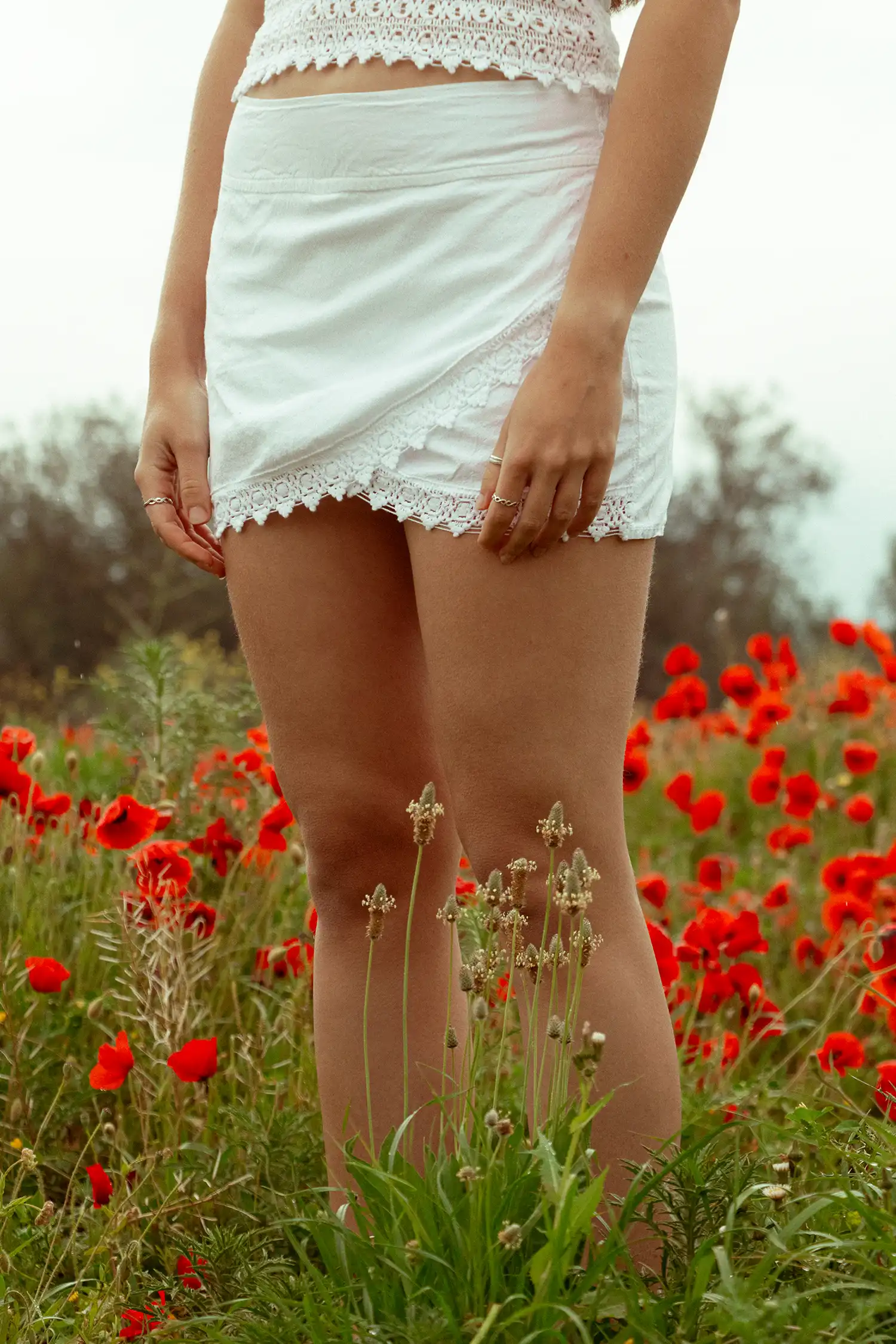 Modelo femenina con una falda ibicenca blanca en un campo de flores