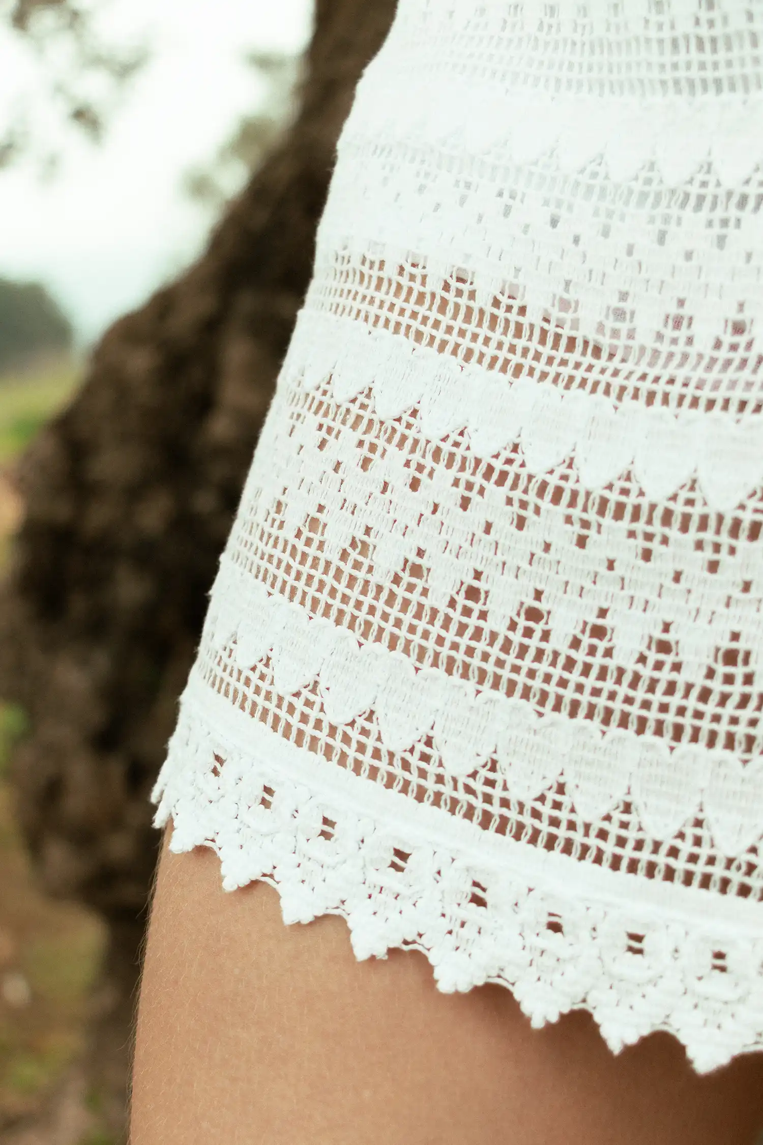 Modelo femenina con una falda ibicenca blanca en el campo vista detalle