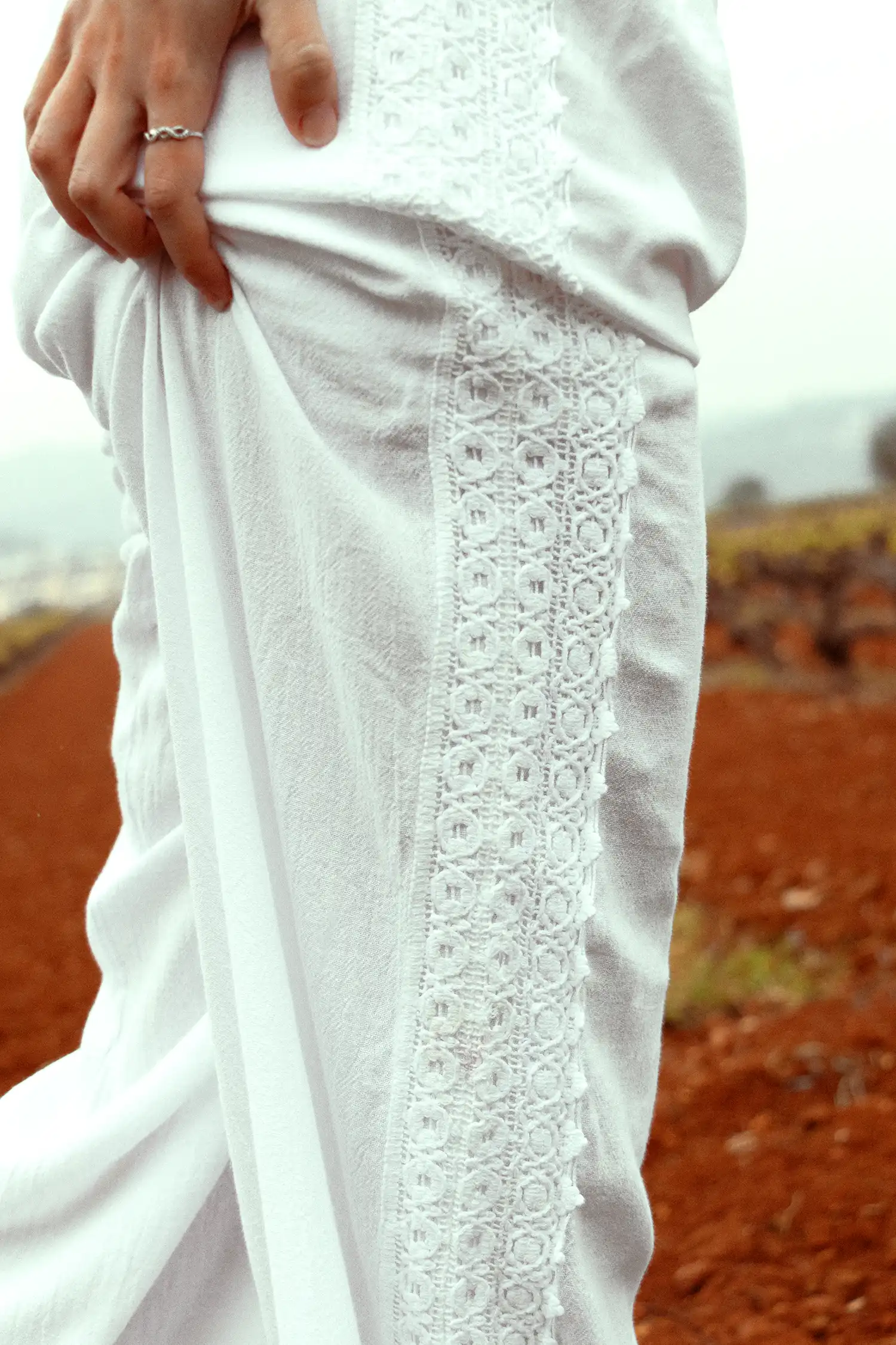 Pantalón ibicenco de mujer blanco en un campo de viñas, vista detalle del lateral