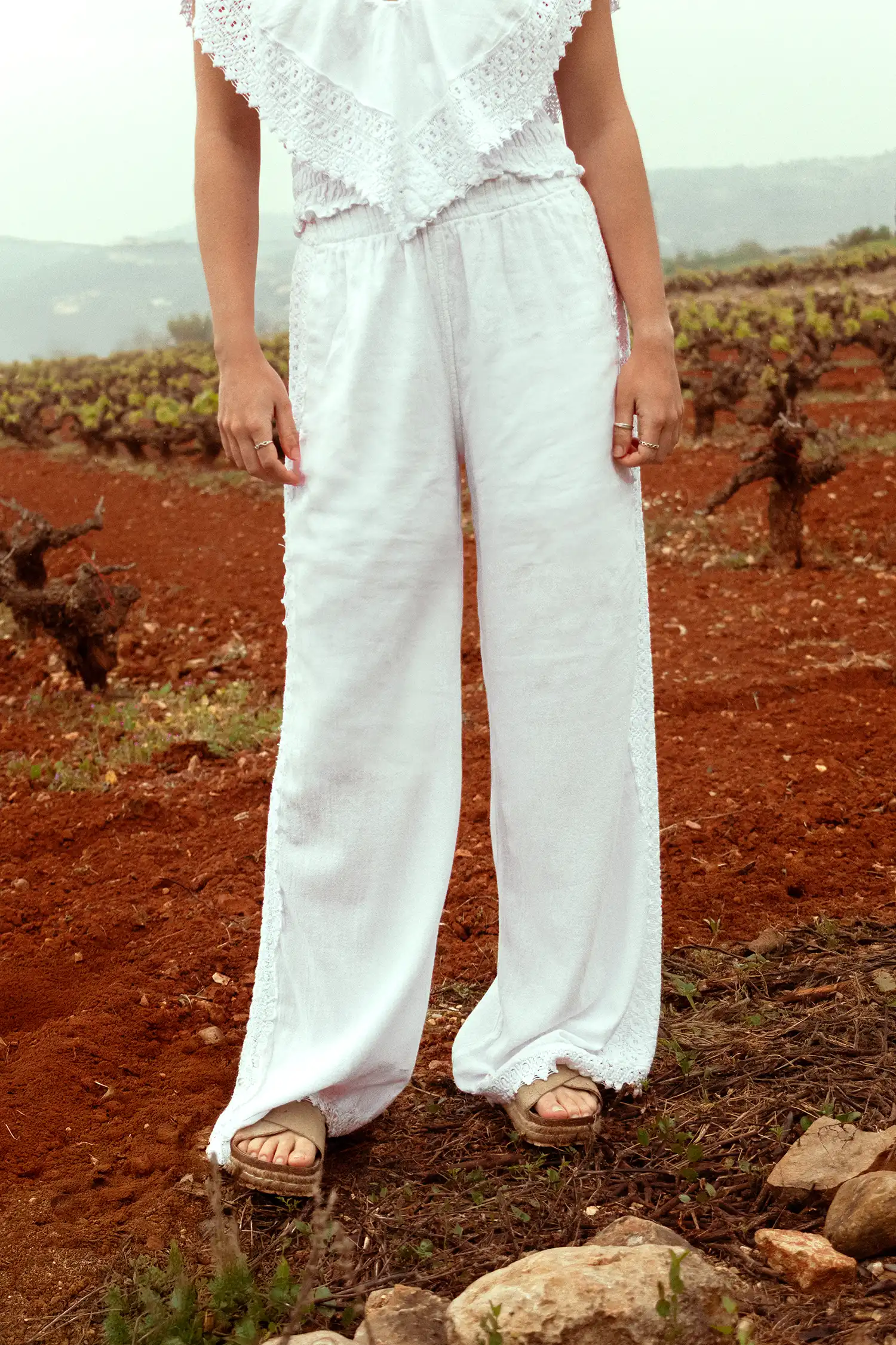 Pantalón ibicenco de mujer blanco en un campo de viñas, vista frontal