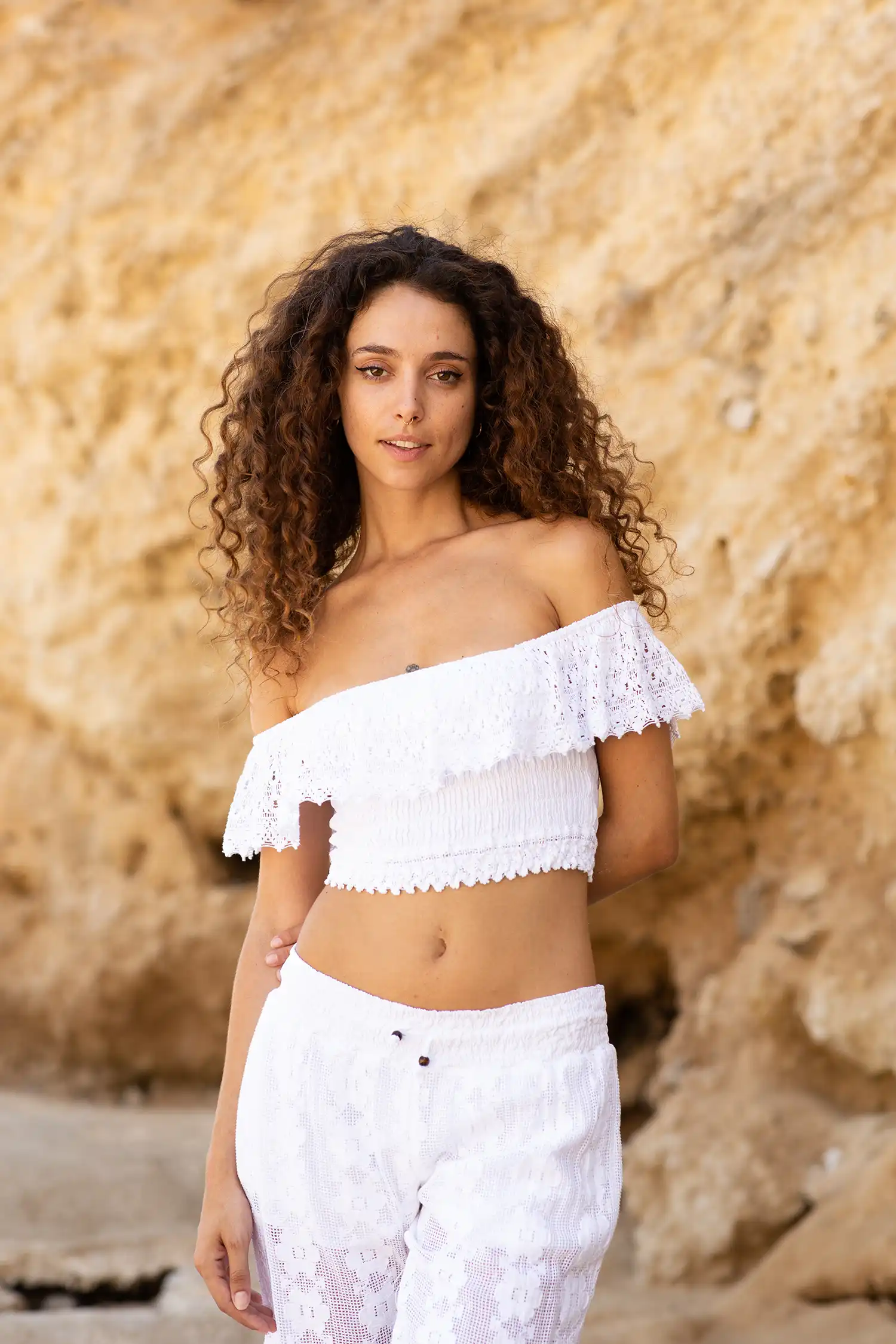 Modelo femenina con top ibicenco blanco en la playa vista ampliada