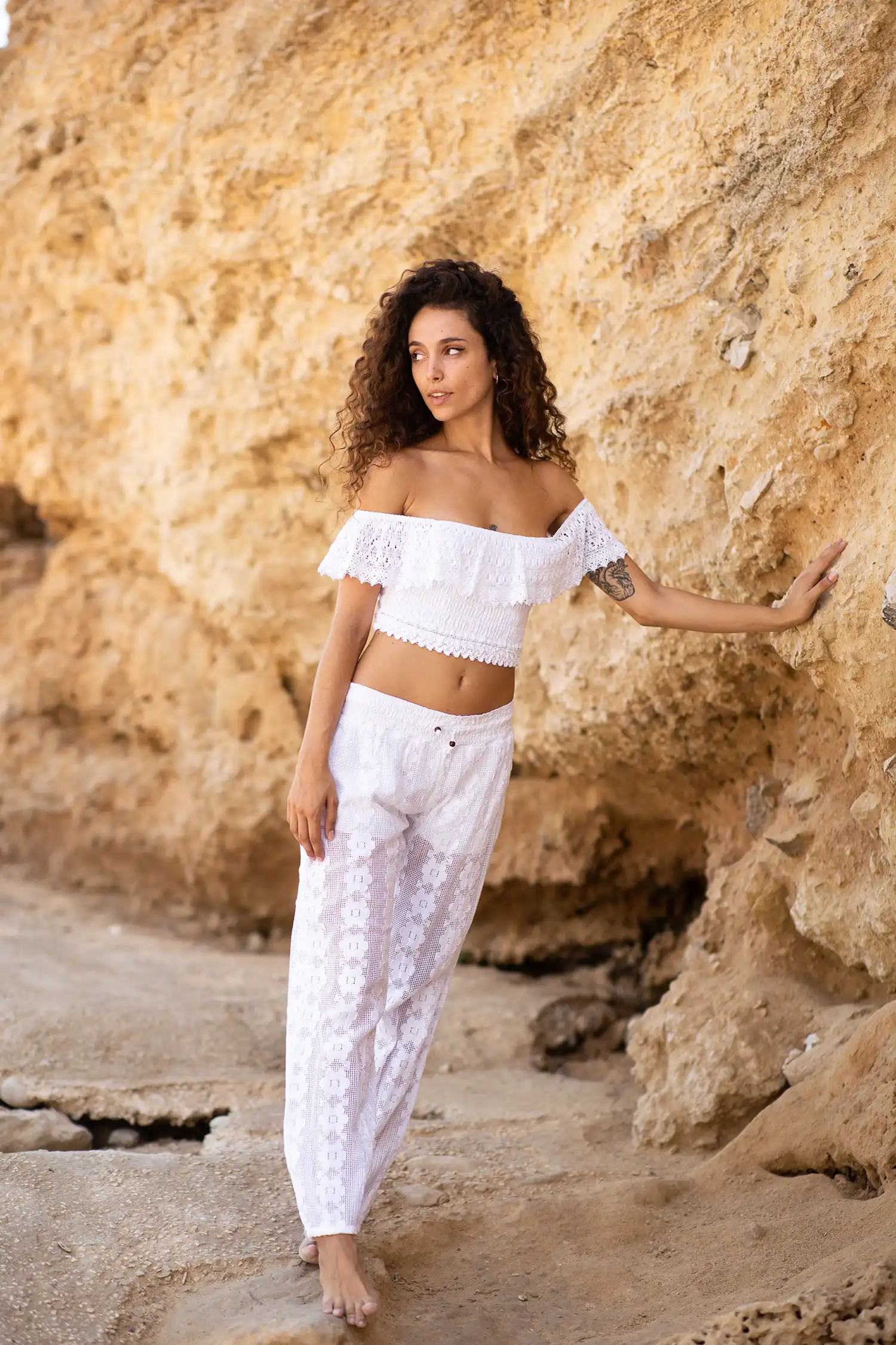 Modelo femenina con top ibicenco blanco en la playa vista abierta