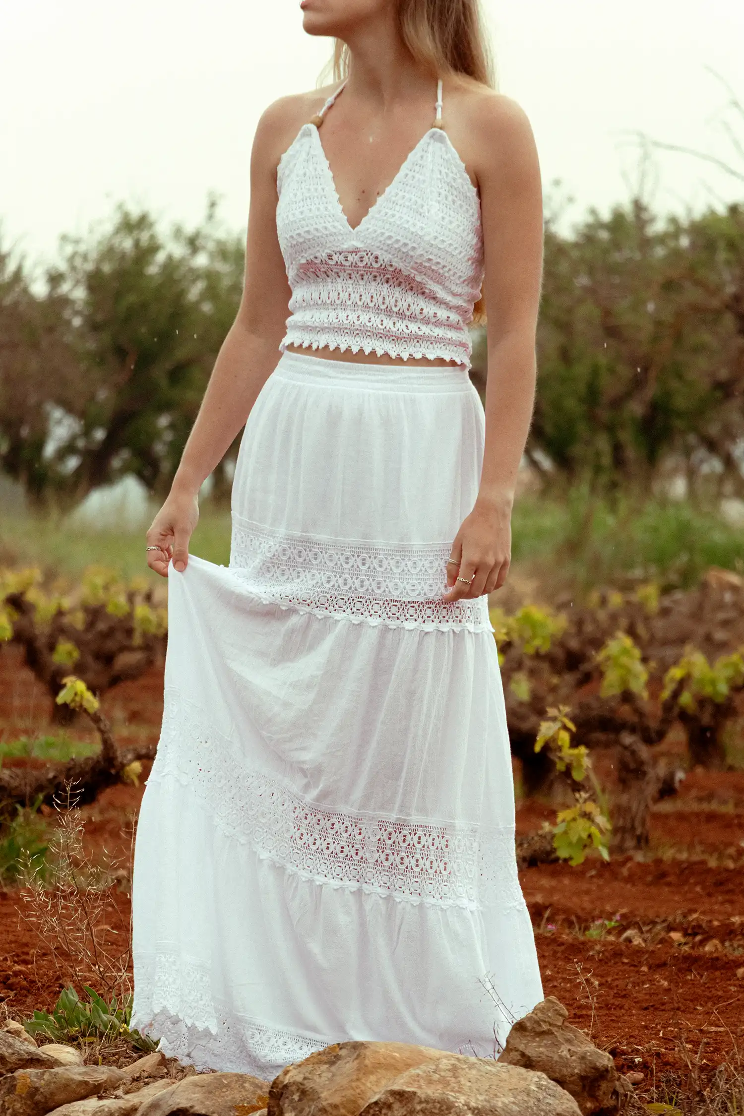 Modelo femenina con un top ibicenco blanco en el campo