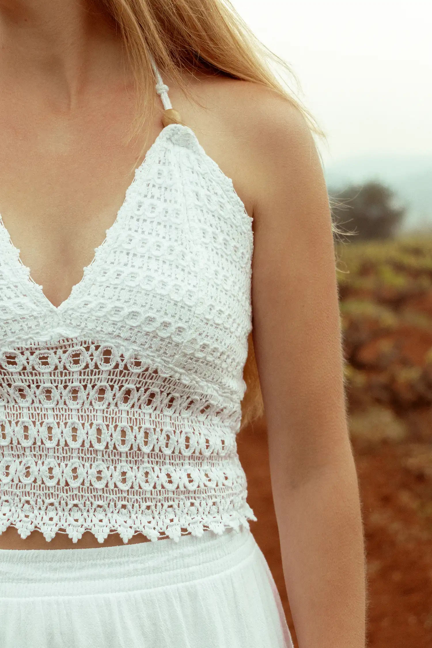 Modelo femenina con un top ibicenco blanco en el campo vista detalle